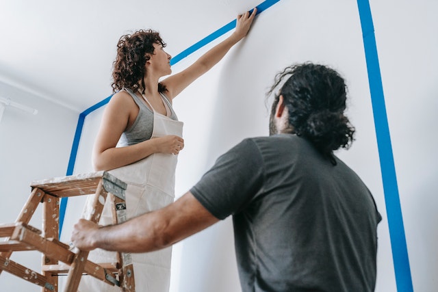 two renters setting up a room to paint a white wall